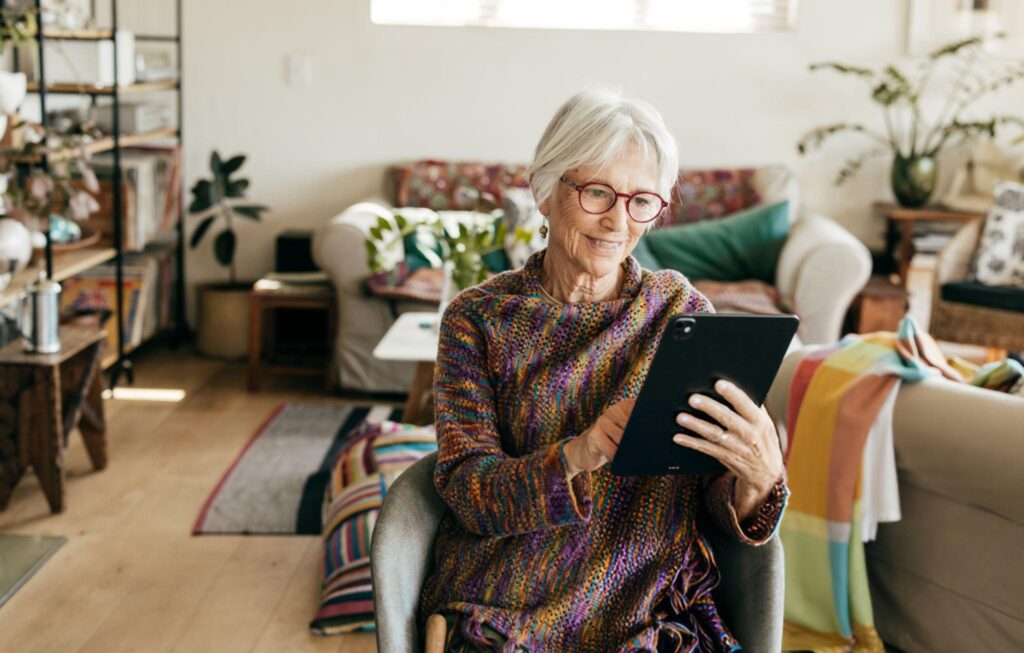 a woman smiling looking at her tablet